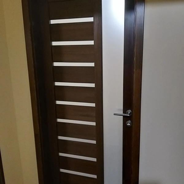 Elkészült szép tömörfa beltéri ajtó modern fogantyúval.